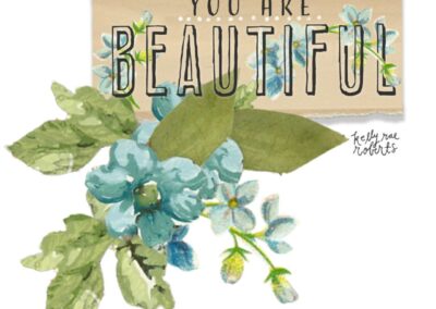 Collage art with "You are beautiful" text across torn paper with blue floral spray underneath.