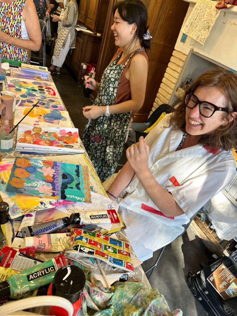 Kelly Rae Roberts retreat participants having fun and laughing while painting.